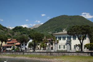 a large white building with a mountain in the background at Casa Domaso in Domaso