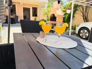two glasses of orange juice on a wooden table at Apartment Irma free parking old town near Bascarsija in Sarajevo