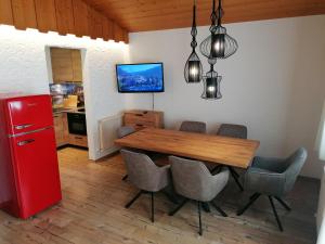 a kitchen with a wooden table and a red refrigerator at Ferienwohnung Martin in Zellberg +21 photos
