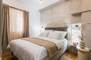 a bedroom with a large bed with a stone wall at Calidum Boutique Suites in Šibenik