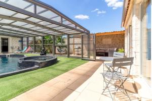 a patio with a pool and a table and chairs at Le logis de la castagne in Caumont-sur-Durance