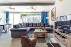 a living room with a couch and a tv at Le logis de la castagne in Caumont-sur-Durance +22 photos