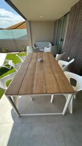 a wooden table with white chairs around it at La Tejita Amor by BE HAPPY Sotavento Suites New 2025 in El Médano
