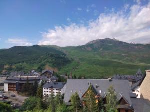 a view of a town with mountains in the background at Ibón de Sarrato in Formigal +2 photos