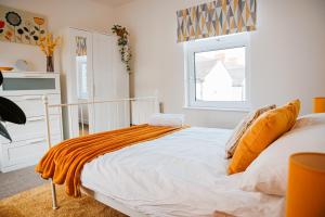 カーディフにあるCosy Stays Cardiffのベッドルーム1室(オレンジの毛布付きのベッド1台付)