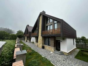 a building with a walkway in front of it at Mount Cottages Bakuriani in Bakuriani