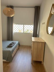 a bedroom with a bed and a table and a mirror at Casa Dalia - One bedroom flat in Torremolinos +19 photos