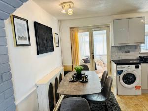 a living room with a table with chairs and a kitchen at Luxe 2 Bedroom House Derby City in Derby