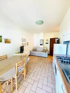una cucina e un soggiorno con un tavolo e un divano di Residence azzurro VISTA MARE-A a Gabicce Mare