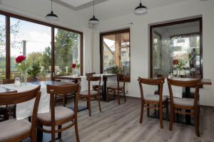 a dining room with tables and chairs and large windows at Penzion u Hanky in Telgárt