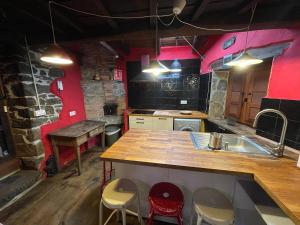 a kitchen with a sink and a counter with stools at La Casa Roja de Quirós 