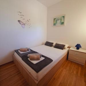 a bedroom with a bed with a butterfly on the wall at Apartment ARIELA in Tisno