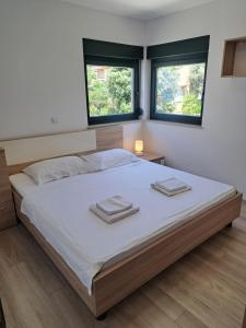 een slaapkamer met een groot bed met twee handdoeken erop bij Beach apartment in Mandre in Mandre