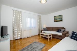 a living room with a couch and a table at Rooms and Apartments Lidija in Lopar