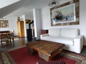 a living room with a white couch and a wooden coffee table at Stadtvilla in Kiel