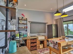 a kitchen with a table and a large screen on the wall at Nyathi Hideaway in the Berg in Bergview