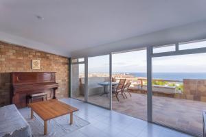 a living room with a piano and a table at Surf-Check House - 3 min walking to the Beach in Playa del Hombre +26 photos