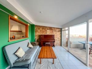 a living room with a couch and a piano at Surf-Check House - 3 min walking to the Beach in Playa del Hombre