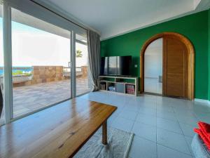 a living room with a wooden table and a television at Surf-Check House - 3 min walking to the Beach in Playa del Hombre