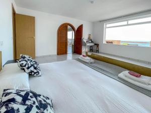 a large bed in a room with a large window at Surf-Check House - 3 min walking to the Beach in Playa del Hombre