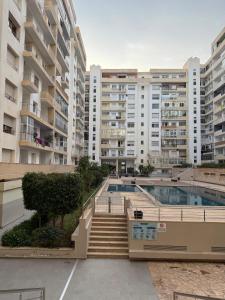 een gebouw met een zwembad en enkele gebouwen bij Sweet Home Agadir Appartement moderne avec piscine et commerces à pied in Agadir