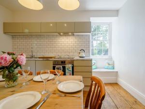 a kitchen with a wooden table with plates and wine glasses at 3 Bed in Crosthwaite 75564 in Crosthwaite +19 photos