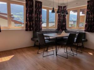 a dining room with a table and chairs and windows at Das Moos in Ried im Zillertal