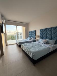 a bedroom with two beds and a large window at Serena del Mar, Morros IO in Cartagena de Indias +20 photos