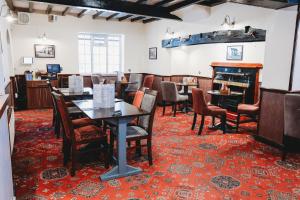 a dining room with tables and chairs and a fireplace at The Appleby Inn Hotel in Appleby Magna