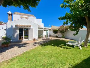 a yard with a white house and a table at Chalet Pleamar, a 2 minutos de la playa in Los Caños de Meca