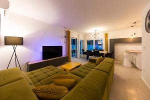 a living room with a green couch and a television at Alba Family Home in Zadar