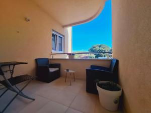 a room with two chairs and a table and a window at Apartment ARIELA in Tisno