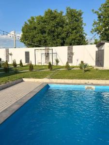 a swimming pool with blue water in front of a building at ARThouse Garni in Garni