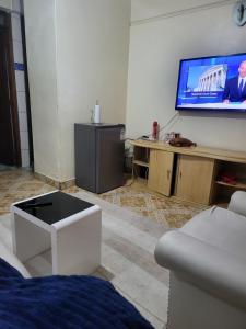 Una sala de estar con un televisor en la pared. en G&G Executive Homes NAKURU, en Nakuru
