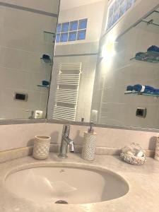 a bathroom sink with a large mirror above it at WELCOME RIVIERA Primavera 1A Vista mare- spazioso e comodo appartamento-2 bagni-wifi-aria condizionata in ogni stanza-garage a pagamento 15 euro al giorno in Rapallo