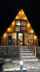 a house with stairs and a light in front of it at Nora's Chalet in Fshati i Ri