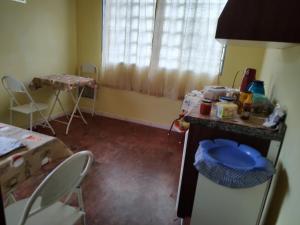 a kitchen with a counter and a table and chairs at Pousada Sothie in São Bento do Sapucaí