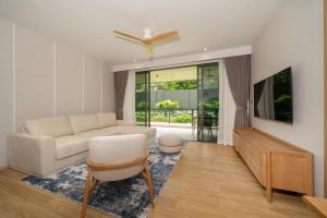 Una sala de estar con un sofá y un televisor. en Apartment at Laguna Beachside by Lofty, en Bang Tao Beach