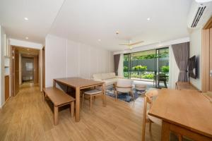 Una sala de estar con una mesa y sillas y un sofá. en Apartment at Laguna Beachside by Lofty, en Bang Tao Beach