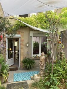 a small house with a statue in the front yard at Le Nid de Marguerite in Castelnaudary