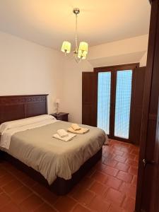 sypialnia z łóżkiem i żyrandolem w obiekcie Apartamentos Bodeguetas w mieście Constantina