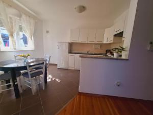 a kitchen and dining room with a table and a table and chairs at Apartment ARIELA in Tisno +6 photos