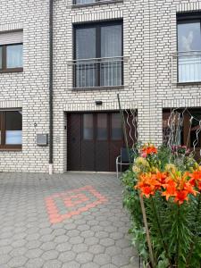 a brick house with a garage and some flowers at Monteurzimmer mit Küchennutzung in Bad Essen