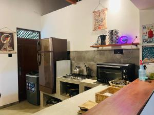 a kitchen with a refrigerator and a stove top oven at Marisol Villa in Unawatuna