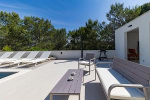 a rooftop patio with benches and a swimming pool at Alba Family Home in Zadar