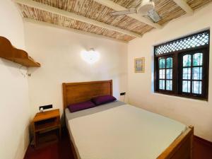 a bedroom with a bed and a window at Marisol Villa in Unawatuna