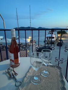 a bottle of wine and two wine glasses on a table at Anemologio Fine Village Living in Ayía Kiriakí