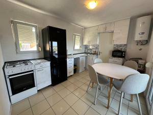 a kitchen with a table and a table and chairs at Apartments Kovač in Vir +38 photos