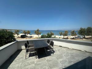 a wooden table and chairs on a balcony with the beach at Apartments Kovač in Vir
