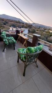 two chairs and a table on a balcony with a view at The Mastiha Spot 1 in Chios